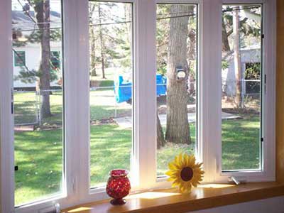 Tall white Thermo-Tech windows overlooking the side of the home