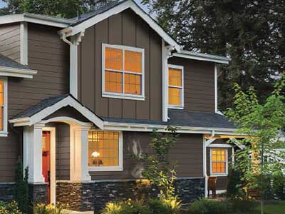 Front view of a mid-class home with dark brown Everlast siding